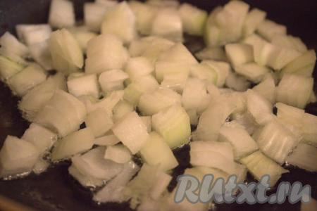 В сковороду влить растительное масло, разогреть на среднем огне, а затем выложить нарезанный лук и обжарить, помешивая, в течение 1-2 минут.