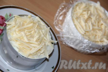 Сыр натереть на тёрке и выложить поверх яиц. Салат накрыть пищевой плёнкой и поставить на пару часов в холодильник.