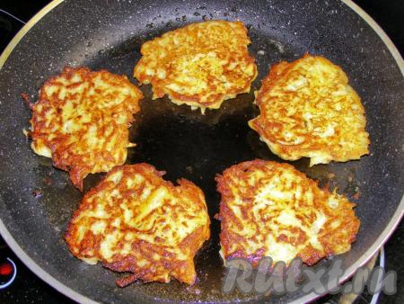 Жарим картофельные драники с луком на среднем огне до появления золотистой корочки, затем переворачиваем и обжариваем до золотистого цвета с другой стороны. Готовые драники складываем в кастрюльку (или на тарелку). В сковородку подливаем ещё немного масла и выкладываем следующую порцию. Таким образом жарим все драники.