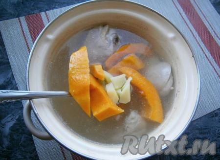 После того как куриное мясо проварится 10-15 минут, в кастрюлю добавить картофель и очищенную тыкву, нарезанную довольно крупными кусками.