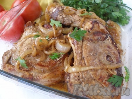 Готовое блюдо достать из духовки. Свиные стейки, замаринованные в соевом соусе, можно подать вместе с луком, с которым запекалось мясо.