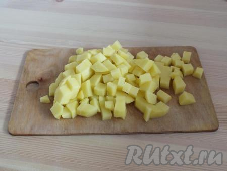 Почистите картофель, лук и морковь. Картофель и лук нарежьте на средние кубики. Морковь натрите на крупной тёрке. На сковороду влейте 3 столовые ложки масла, разогрейте, выложите лук с морковкой и обжарьте до мягкости, иногда помешивая, на среднем огне (в течение 5-7 минут).