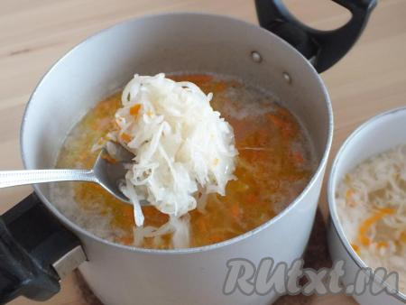 Как только картофель сварится, в суп с перловкой добавьте обжаренные лук и морковь, отваренную квашеную капусту, если нужно, посолите и варите рассольник 15 минут.