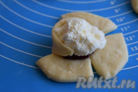 Начинаем сворачивать розочки, для этого огибаем начинку тестом (как на фото), сначала скрепляем между собой противоположные лепестки, затем таким же образом скрепляем оставшиеся 2 лепестка.