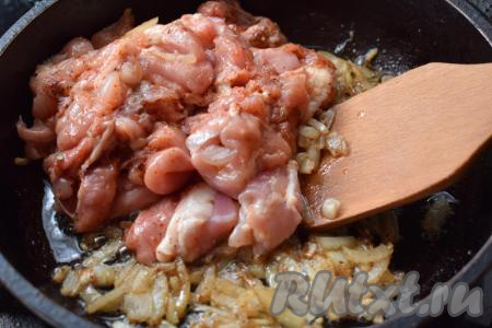 К обжаренному луку добавляем кусочки курицы.