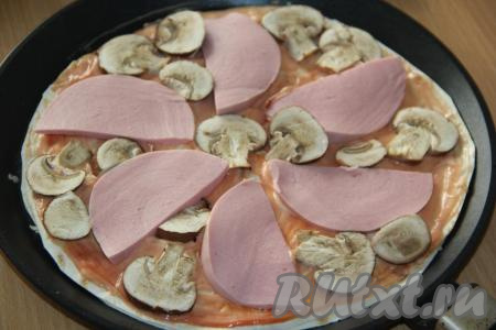 Колбасу нарезать на тонкие ломтики и выложить на смазанный лаваш. Шампиньоны промыть, обсушить и, нарезав на достаточно тонкие пластинки, выложить между кусочками колбасы.