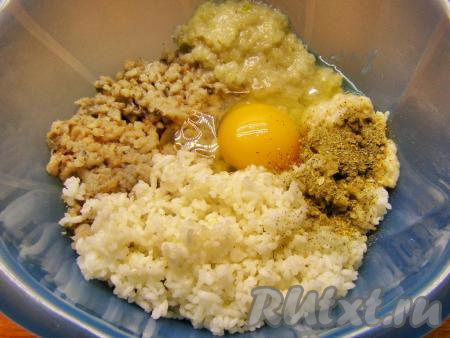 Пропускаем через мясорубку рыбу, лук и отжатый от воды хлеб. Добавляем остывший рис, сырое яйцо и приправу для рыбы. Тщательно перемешиваем фарш руками до однородного состояния, можно немного посолить.