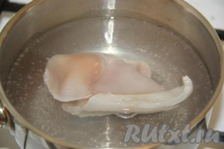 Тушки кальмаров разморозить при комнатной температуре, затем снять тёмную плёночку с каждой тушки и вынуть хорду, расположенную внутри. Воду в кастрюле довести до кипения, опустить 1 тушку кальмара, варить 10 секунд и достать из кипятка. Как только вода снова закипит, опустить следующую тушку. Варёных кальмаров остудить.