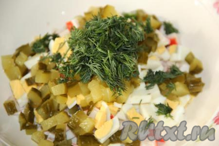 Зелень (у меня укроп) вымыть и мелко нарезать. Добавить огурцы и укроп в салат из кальмаров, крабовых палочек и яиц.