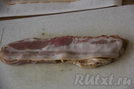 Поверх свинины выложить полоску бекона.
