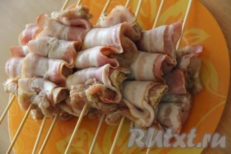 Шпажки предварительно замочить в воде на 1 час. Нанизать свинину с беконом в виде гармошки на шпажки. Вместо деревянных шпажек можно взять шампуры.