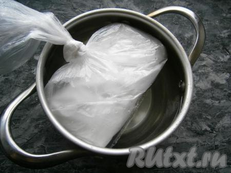 В кастрюлю налить холодную воду и выложить в неё пакет с салом. Воды должно быть столько, чтобы сало плавало в ней и при погружении вода его покрывала полностью.