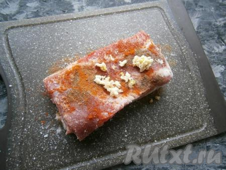 Натереть солью, чёрным и красным молотыми перцами, а также пропущенным через пресс чесноком.