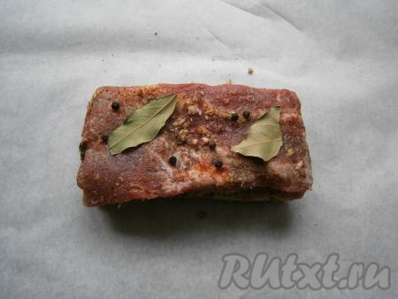 Сало поместить на лист пергамента, сверху разместить лавровые листья и чёрный перец горошком.