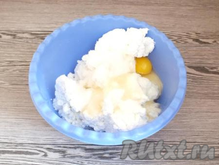 Для приготовления сырников из творога с кокосовой стружкой, возьмите глубокую миску, выложите в неё творог, разбейте 2 яйца, добавьте сахар. Тщательно перемешайте творожную массу ложкой (или воспользуйтесь погружным блендером).