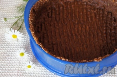 Распределить основу для коржа по дну разъёмной формы (я использовала силиконовую разъёмную форму диаметром 23 сантиметра), сформировать бортики, как на фото. Убрать основу чизкейка в холодильник на 15 минут. Тем временем, взять 15 грамм желатина, всыпать в небольшую ёмкость, влить 5 столовых ложек холодной кипячёной воды, перемешать и оставить набухать на 15-20 минут.