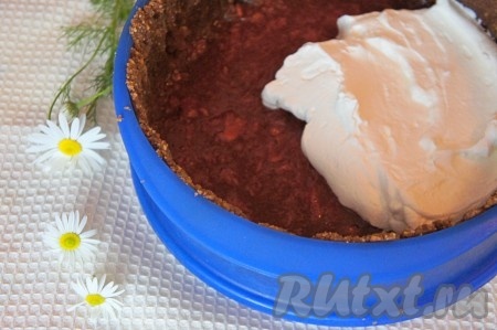 Для получения сливочного слоя в отдельной ёмкости хорошо охлаждённые сливки взбить с сахаром миксером до стойких пиков. Набухший желатин разделить на 2 равные части. Одну часть набухшего желатина прогреть в микроволновке (или на плите) до полного растворения кристалликов желатина, не доводя до кипения. Я прогреваю желатин в микроволновке, для этого ставлю ёмкость с набухшим желатином на 10 секунд на максимальную мощность в микроволновку, достаю, перемешиваю. Если кристаллики желатина полностью растворились, значит больше прогревать не нужно. Если не все кристаллы растворились, значит нужно поставить в микроволновку ещё на 10 секунд. Главное, чтобы желатин не закипел. Прогретый желатин немного охладить, добавить его во взбитые сливки, перемешать миксером и сливочный слой чизкейка готов. Выложить сливочный слой поверх песочной основы, разровнять ложкой и отправить на 20 минут в холодильник.