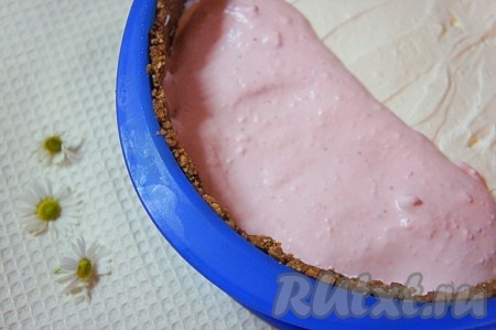 Распределить клубнично-творожный слой поверх застывшего сливочного слоя. Отправить чизкейк, приготовленный с клубникой, сливками и творогом, в холодильник минимум на 2 часа (до полного застывания).