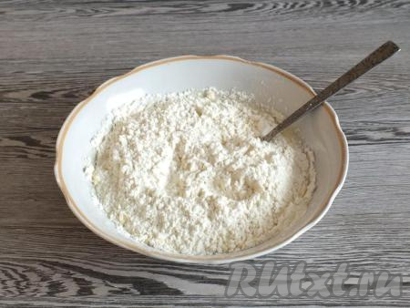 В получившуюся массу всыпьте частями муку, каждый раз хорошо перемешивая тесто вилкой. Когда станет трудно перемешивать вилкой, начните замес руками.