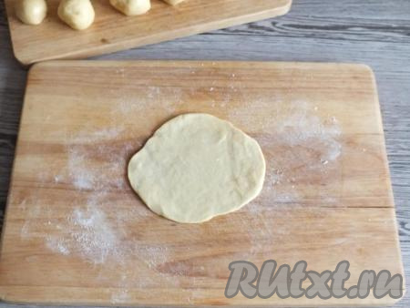 Натрите доску (или поверхность, на которой будете раскатывать тесто) 0,5 столовой ложки муки. Возьмите одну часть теста и раскатайте в круглую тонкую лепёшку толщиной в пределах 3-4 мм.
