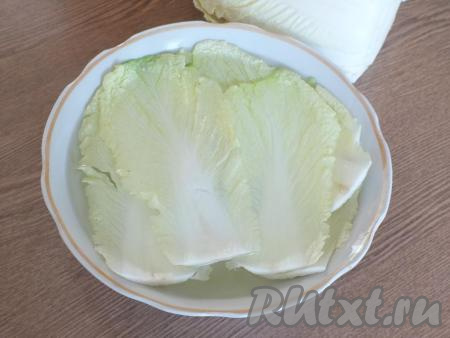 Вскипятите воду. Налейте крутой кипяток в глубокую миску. Выложите в миску с кипятком листы пекинской капусты (листы должны быть полностью покрыты водой) и оставьте на 10 минут. Если листочки всплывают, опускайте их в кипяток с помощью вилки.