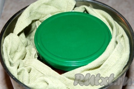 Завернуть банку с помидорами в кухонное полотенце (полотенцем должно быть завёрнуты и низ, и бока банки) и поместить в кастрюлю с тёплой водой, которая должна быть по "плечики" банки. Довести воду в кастрюле на среднем огне до кипения, уменьшить огонёк и держать кастрюлю с банкой на огне 20 минут.
