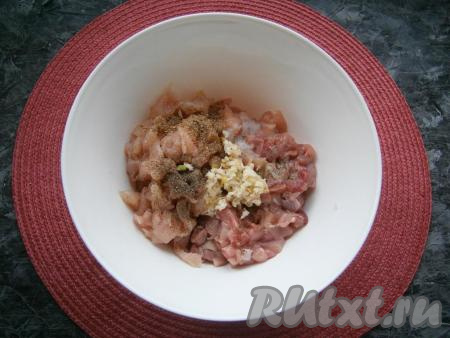 К нарезанному куриному мясу добавить соль, кориандр, мускатный орех, белый и чёрный молотые перцы, а также пропущенный через пресс чеснок.