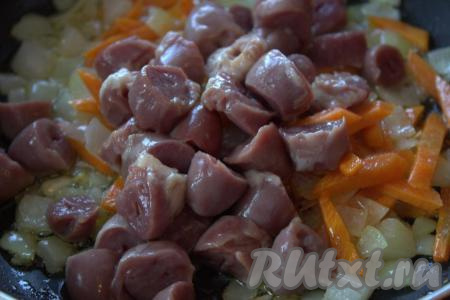 В сковороду с обжаренными овощами выложить нарезанные куриные сердечки, перемешать. Обжаривать сердечки с овощами, периодически перемешивая, примерно, 10 минут. Посолить по вкусу.