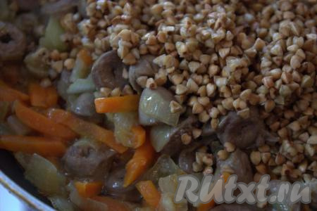 Затем в сковороду к обжаренным овощам и куриным сердечкам выложить гречневую крупу, перемешать. Если нужно, ещё раз посолить, всыпать специи по вкусу и обжарить, помешивая, 5 минут.