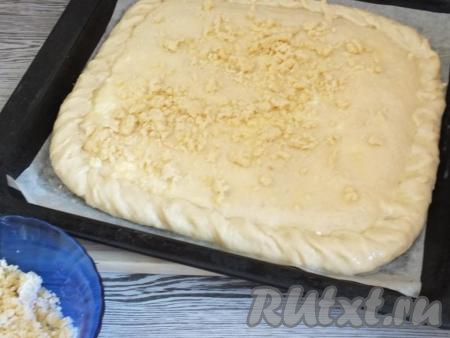 Края пирога заверните в "верёвочку". Достаньте посыпку из холодильника. Верх пирога смажьте яичным желтком. Сверху равномерно распределите посыпку.