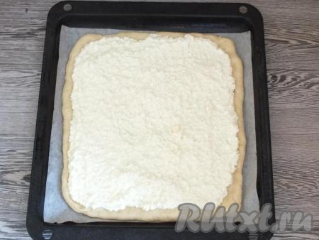 На пласт теста распределите творожную начинку, оставляя края (примерно, 2 см от края) без начинки.&nbsp;Если начинка выделила жидкость, её необходимо предварительно слить.