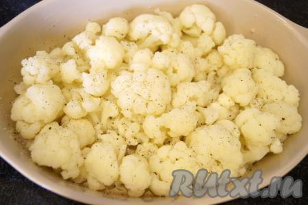 Смазываем сливочным маслом форму для запекания (размер моей формы 28х20 см), выкладываем отваренную цветную капусту, посыпаем по вкусу молотым чёрным перцем.