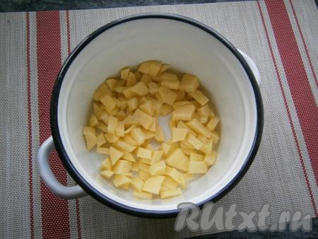 Отдельно отварить два яйца в течение минут 10 с начала кипения воды, после остывания очистить их. Нарезать на кубики очищенный картофель, выложить в кастрюлю, залить 1,8 литрами воды, поставить на огонь. После закипания посолить воду, довести до кипения и варить картошку на небольшом огне 15 минут.