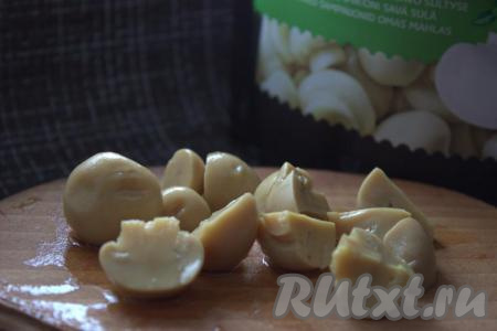 Крупные маринованные грибы разрезать на несколько частей (слишком мелко резать не нужно). Например, крупные маринованные грибы можно разрезать на 4-6 частей.