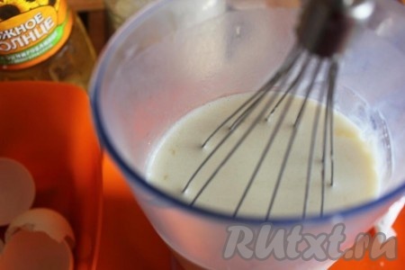 Затем вбить сырые яйца, всыпать сахар и соль. Перемешать тесто венчиком. Влить частями оставшиеся 250 миллилитров молока, постоянно перемешивая тесто венчиком. Добавляя молоко, мы регулируем густоту блинного теста. Вливая молоко учитывайте, что тесто должно быть достаточно жидким, но и совсем жидким, как вода, оно быть не должно. В конце влить растительное масло и тщательно перемешать.