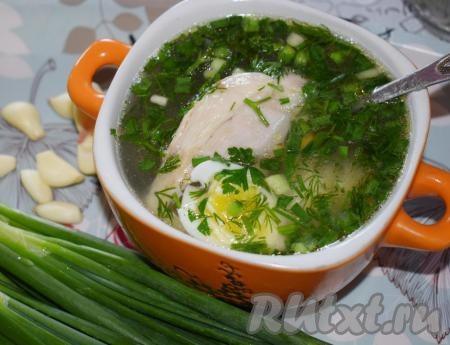 Далее достаём из бульона варёную курицу и режем её на порционные кусочки. Горячий бульон разливаем по тарелкам, кладём кусочки курочки, нарезанное яйцо, добавляем измельчённую зелень с чесноком.