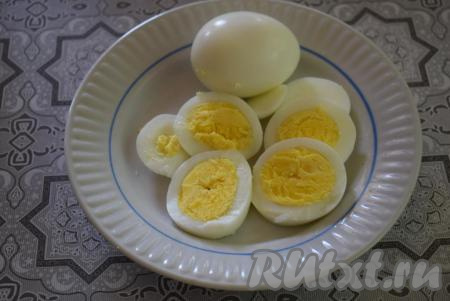 В отдельной кастрюле сварим 2 яйца вкрутую, для этого в холодную воду опускаем яйца и варим их с момента закипания 10 минут. Затем помещаем яйца в холодную воду и очищаем их от скорлупы. Нарезаем яйца на кружочки (можно нарезать на дольки или кубики - здесь всё зависит от вашего вкуса).