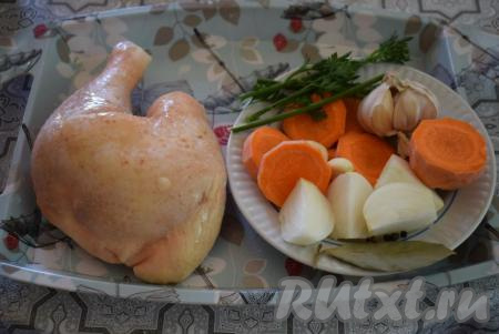 В кастрюлю (я варила в кастрюле объёмом 2,5 литра) наливаем воду, ставим её на огонь. Пока вода закипает, чистим лук и морковь, нарезаем их крупно (лук разрезаем на 4 части, а морковь нарезаем кружочками). Чеснок очищаем от кожицы. Курицу режем на части или используем какую-нибудь часть курицы целиком (я варила бульон из целого довольно крупного куриного окорочка).