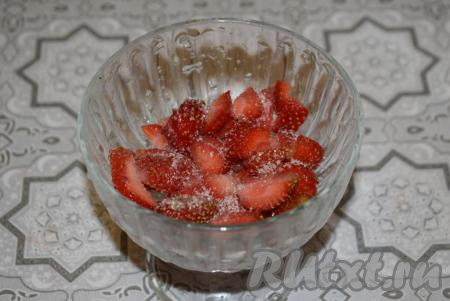 В креманке (или стакане) начинаем формировать наш клубничный десерт, для этого на дно выкладываем 3-4 столовые ложки нарезанной клубники, посыпаем сахаром и хорошо разминаем ягоды с сахаром.