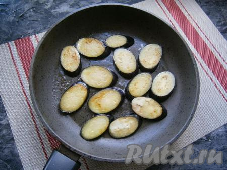 Промокнуть баклажаны бумажным полотенцем, чтобы удалить выделившуюся жидкость, выложить их на разогретую с растительным маслом сковороду. Обжарить баклажаны с двух сторон до румяности на среднем огне.