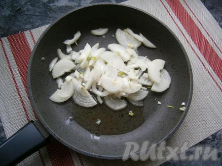 В сковороду с 2 столовыми ложками растительного масла выложить очищенный и нарезанный тонкими полукольцами репчатый лук.