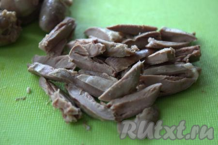 С готовых куриных сердечек слить воду, дать немного остыть, а затем нарезать их брусочками.