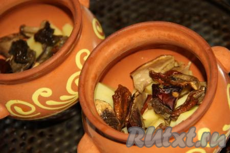 Грибы откинуть на дуршлаг, а затем часть грибочков разложить по горшочкам.