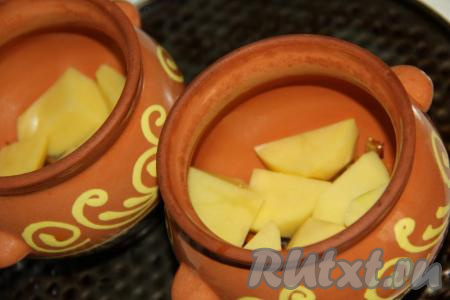 Картофель почистить, нарезать крупными дольками. Часть картошки разложить по горшочкам.