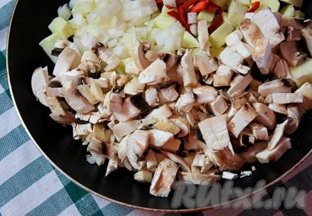 Добавить нарезанные шампиньоны и мелко нарезанный репчатый лук.