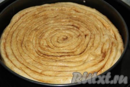 Выложить улитку из теста поверх яблок и горячей карамели, слегка распределить.