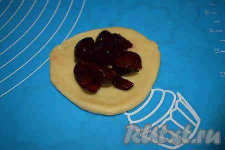 Далее каждый шарик раскатываем в пласт. На середину каждого пласта кладём,&nbsp;примерно, 1 столовую ложку начинки.