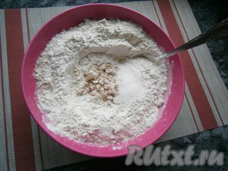 Сделать в муке углубление. В это углубление раскрошить прессованные дрожжи, добавить сахар.