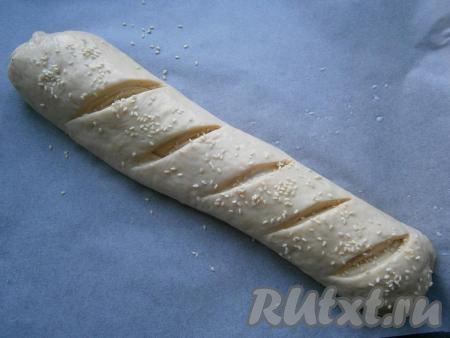 Смазать багет тёплым молоком и посыпать кунжутом. Оставить его в тёплом месте для расстойки на 20-30 минут.