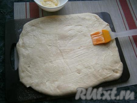 Тесто раскатать в прямоугольник, смазать его частью предварительно размягчённого при комнатной температуре сливочного масла.